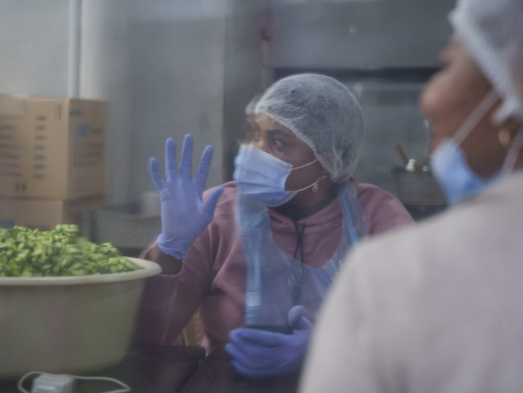 Reflection of a migrant worker preparing food for IDPs.